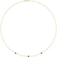 Three lab-grown emeralds in 14K yellow gold bezel settings on an adjustable necklace